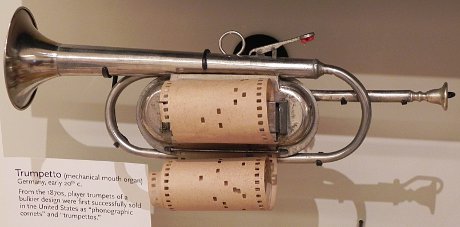 old cornet operating on the principle of the player piano, where a paper roll with holes opens and closes the valves of the cornet